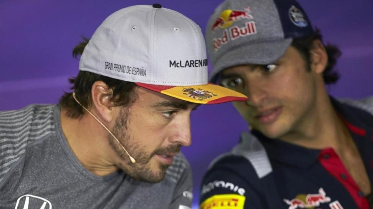 Fernando Alonso atiende a Carlos Sainz.-EFE / ALEJANDRO GARCIA