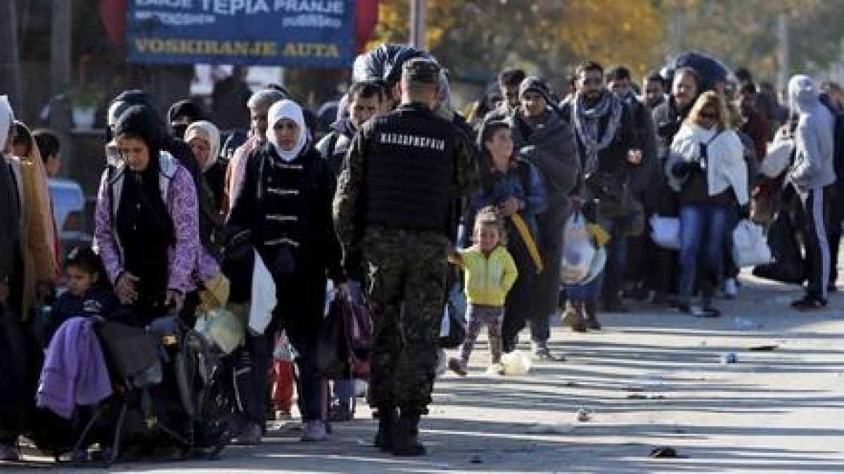 Cientos de refugiados esperan para registrarse en el campamento de Preshevo, en Serbia, este domingo-REUTERS