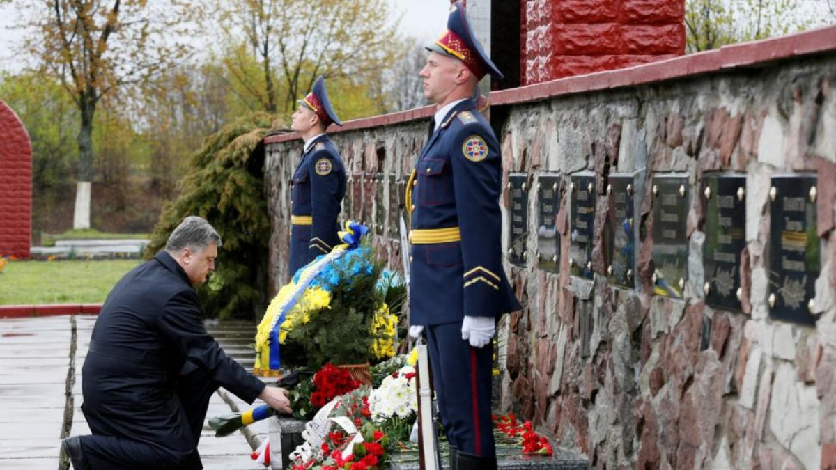 El presidente ucraniano, Petró Poroshenko, deja flores sobre el monumento en honor a los liquidadores de Chernóbil.-REUTERS / VALENTYN OGIRENKO