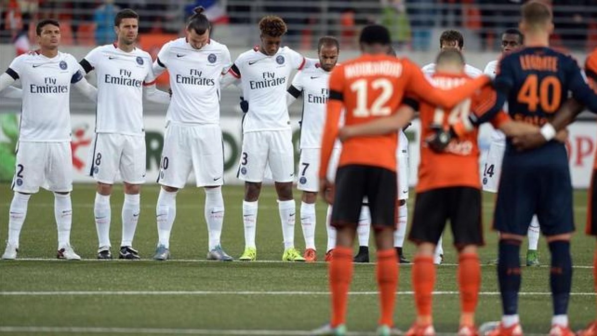 Los jugadores del PSG y del Lorient, durante el minuto de silencio previo al partido-AFP / JEAN-SEBASTIEN EVRARD