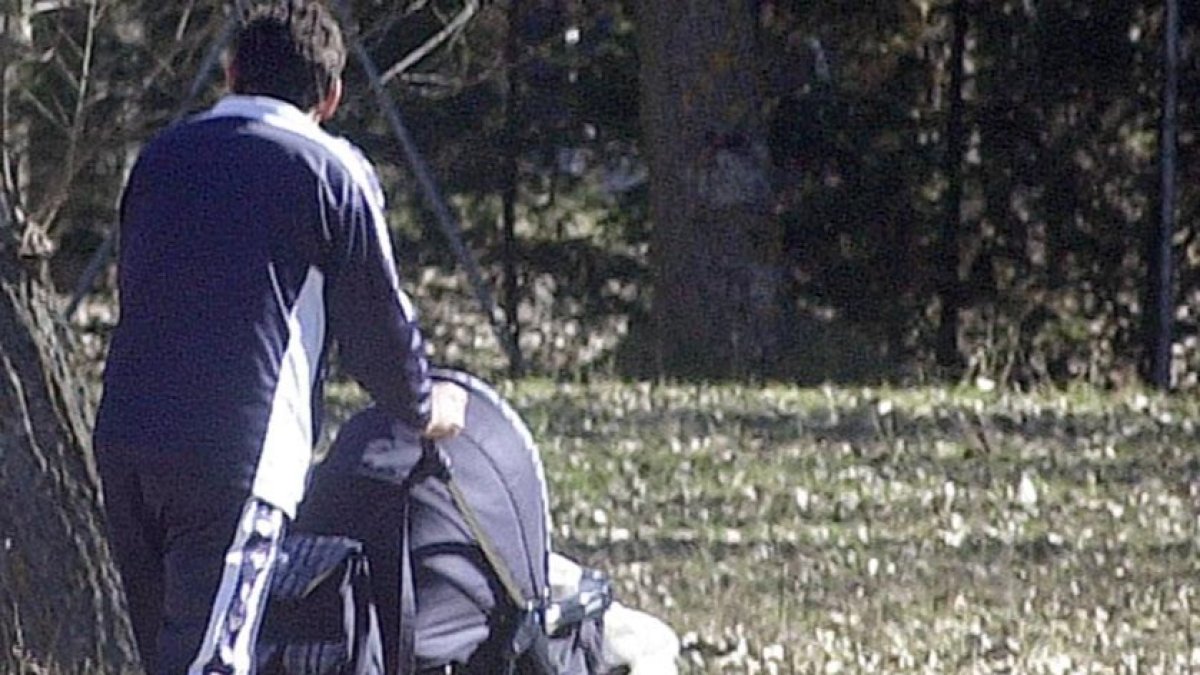 Un padre pasea a su hijo en un carrito.