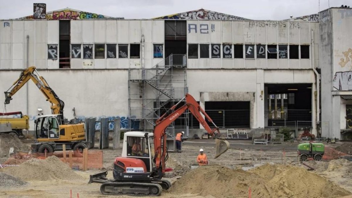 Empleados de la construcción realizan su trabajo en una estación de trenes abandonada para acondicionarla como el primer campo de refugiados de París, este martes.-EFE / IAN LANGSDON