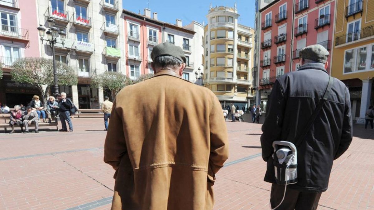 Dos pensionistas paseando por la plaza Mayor de la capital burgalesa.
