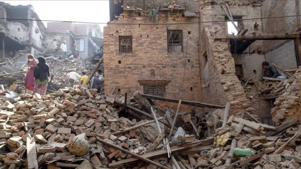 Residentes en Bhaktapur buscan pertenencias entre sus hogares arrasados por el seísmo, este lunes.-Foto: REUTERS / ATHIT PERAWONGMETHA
