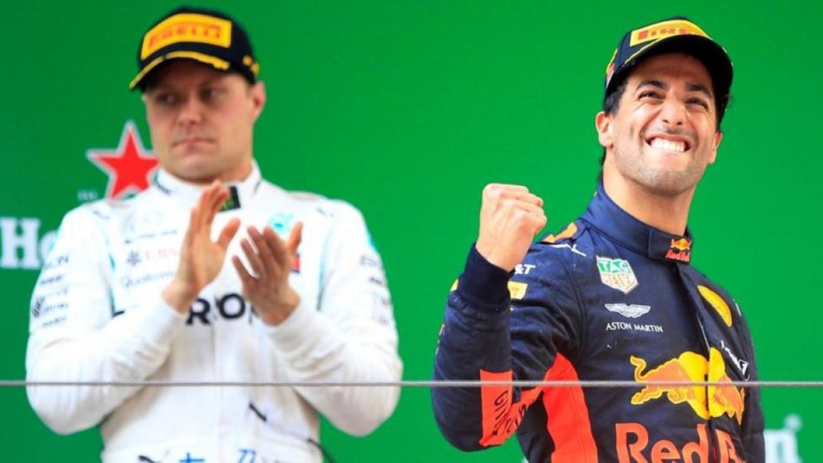 El australiano Daniel Ricciardo (Red Bull) celebra su victoria en China al subir al podio, ante el aplauso de Valtteri Bottas (Mercedes), segundo.-REUTERS / ALY SONG