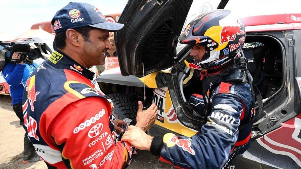 El catarí Al-Attiyah y el francés Peterhansel se saludan, hoy, tras una bella batalla en las dunas de Perú.-AFP / FRANCK FIFE