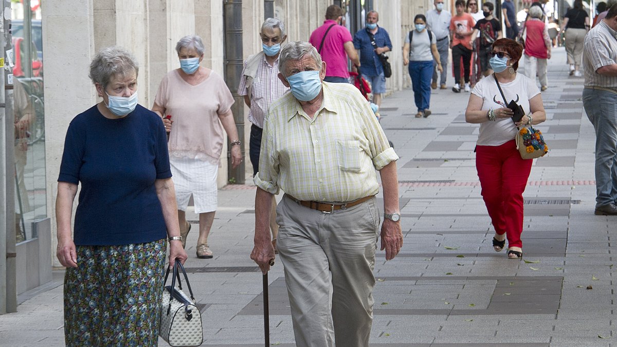 Varias personas con mascarilla caminan por una calle de Burgos.