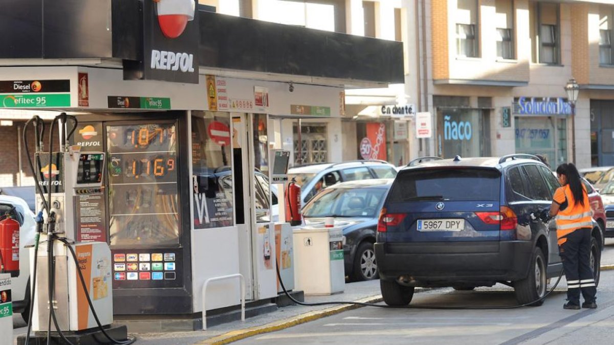 Una trabajadora echa carburante en un vehículo.-ISRAEL L. MURILLO
