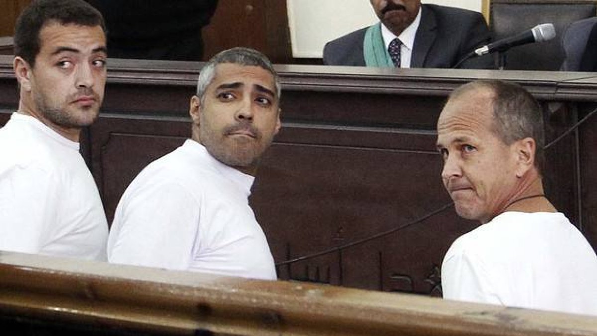 Peter Greste (derecha) junto a sus compañeros de Al Jazira también condenados Mohamed Fahmy (izquierda) y Baher Mohamed (centro), el pasado marzo en un tribunal de El Cairo.-Foto: AP / HEBA ELKHOLY