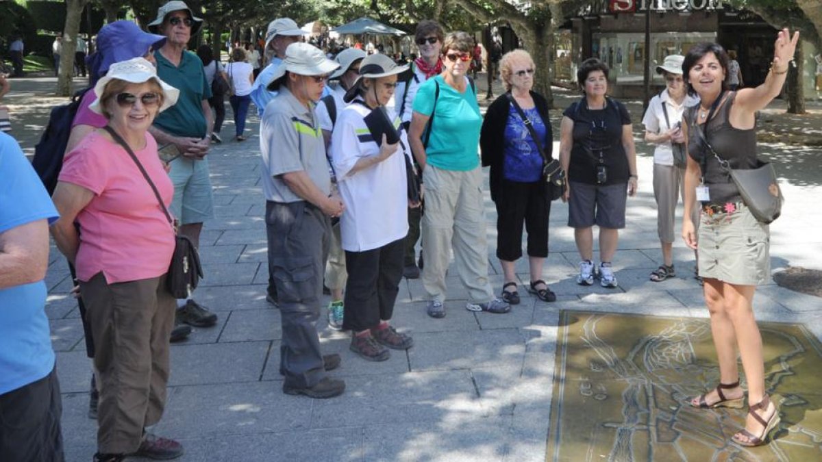 Un grupo de visitantes atiende las explicaciones de una guía de turismo en el paseo de El Espolón.-ISRAEL L. MURILLO
