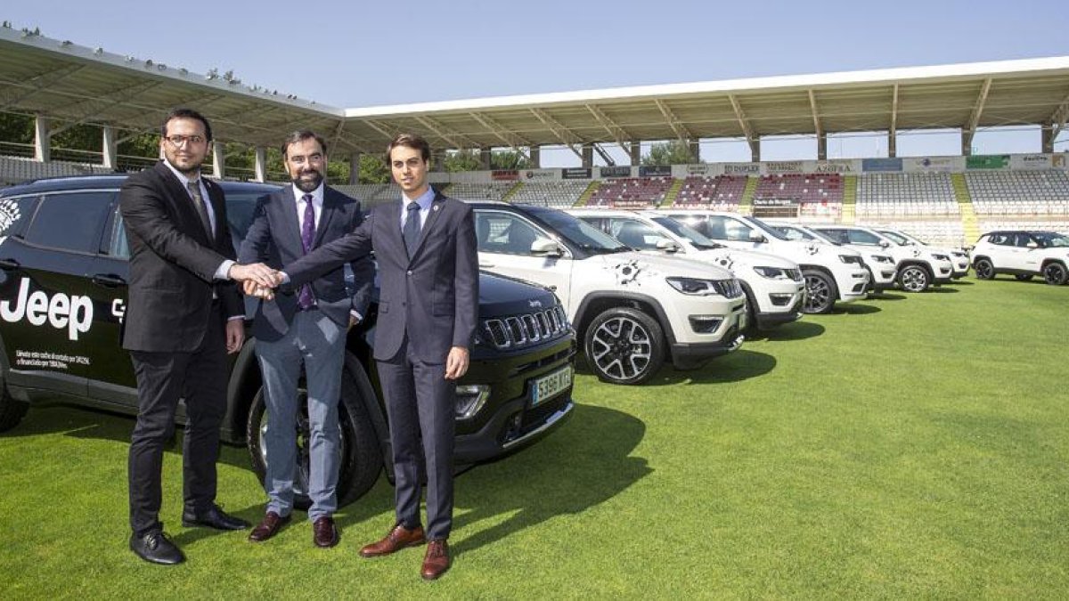 Luis Belli y Franco Caselli escoltan a Julián Alonso durante la presentación de los Jeep que utilizará el personal del club, ayer, en El Plantío.-SANTI OTERO