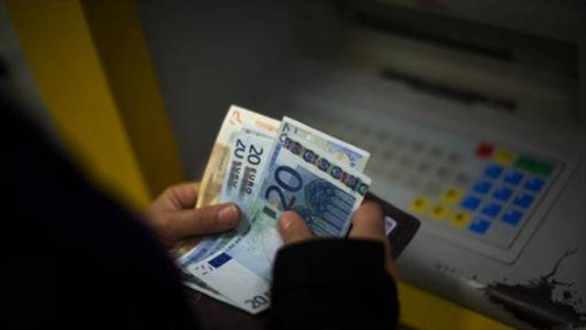 Una mujer saca dinero de un cajero automático. ECB