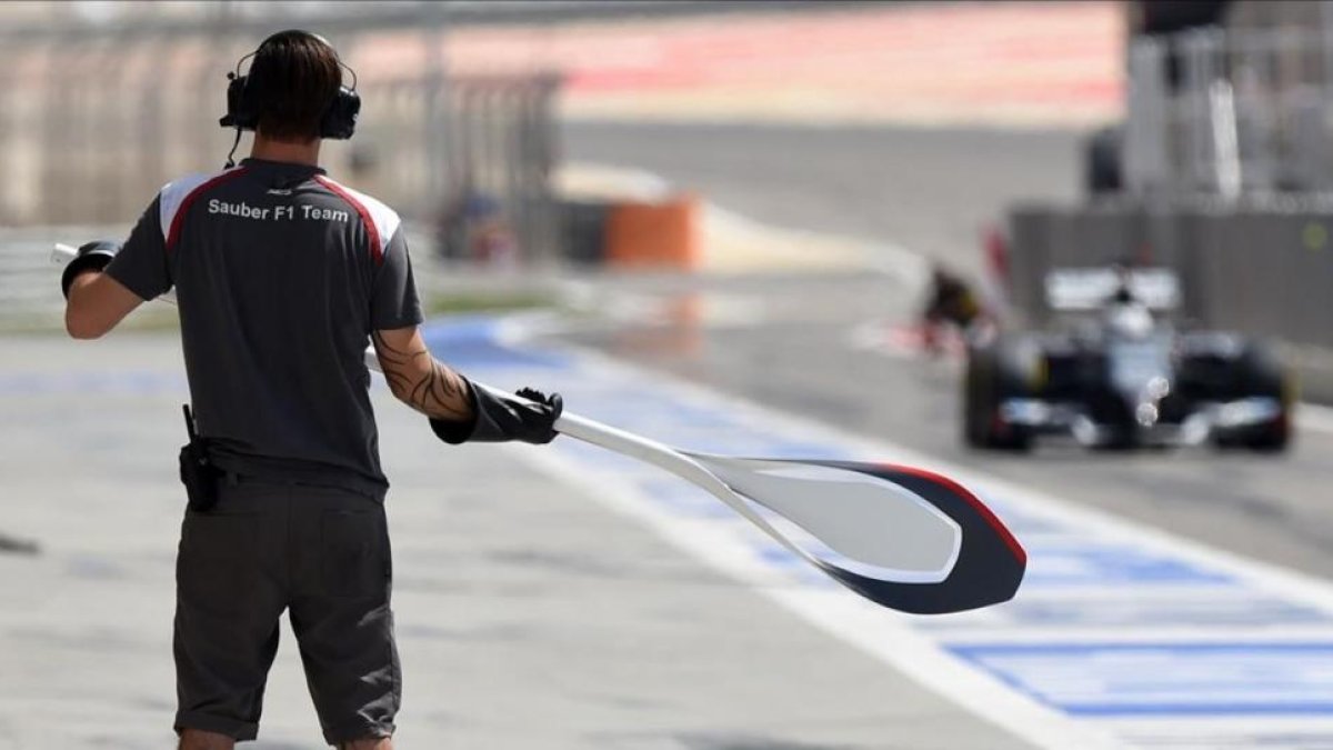 Un mecánico de Sauber espera a su monoplaza en la calle de boxes con la piruleta en sus manos.-JOSÉ MARÍA RUBIO