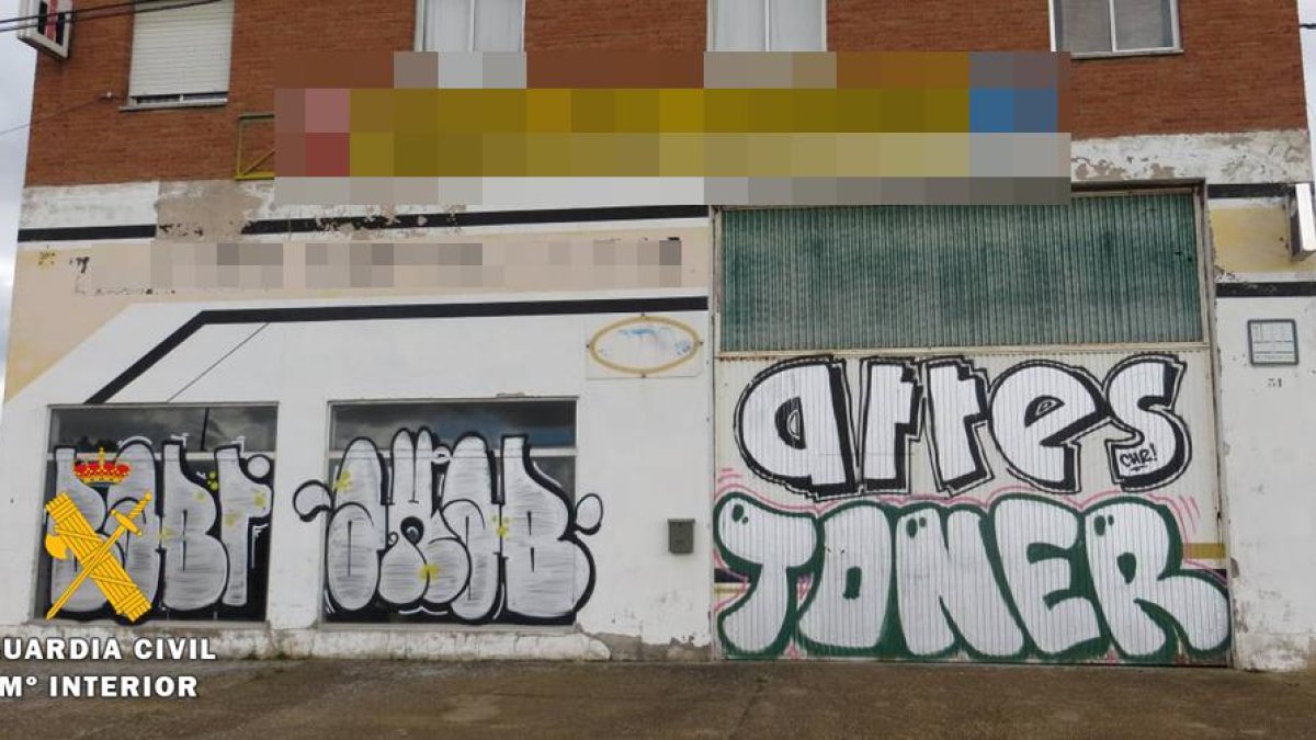 Imagen de grafitis en la fachada de una nave.-ECB