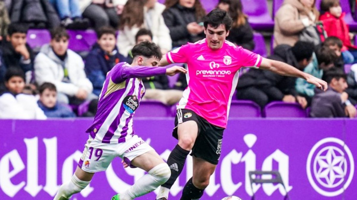 Tito trata de mantener la posesión ante la presión del delantero del Real Valladolid Promesas. Burgos CF