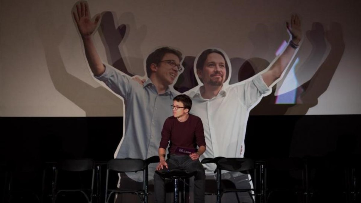Errejón en el escenario de los cines Palafox (Madrid), ante una imagen suya y de Iglesias tomada en enero de 2015 en València-DAVID CASTRO