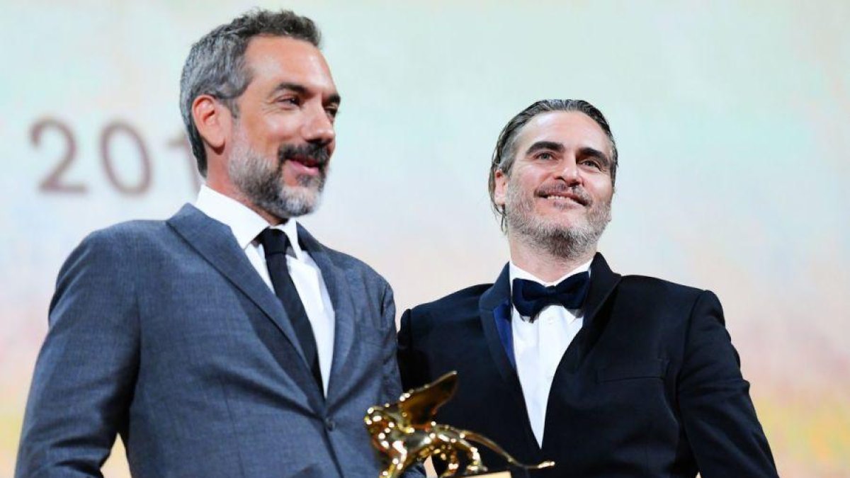 Todd Phillips sujeta el León de Oro junto al actor Joaquin Phoenix.-AFP / ALBERTO PIZZOLI