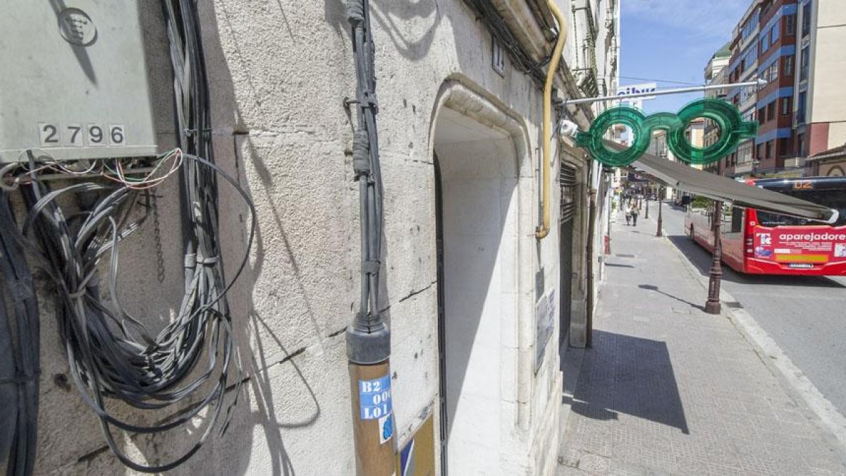 En primer plano, caja de cableado de fibra óptica instalado en la fachada de un edificio de la calle San Pablo.