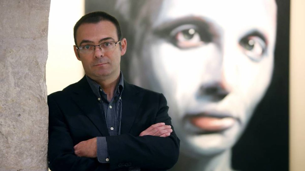 Enrique Barrio, con una de sus pinturas detrás.-Raúl Ochoa