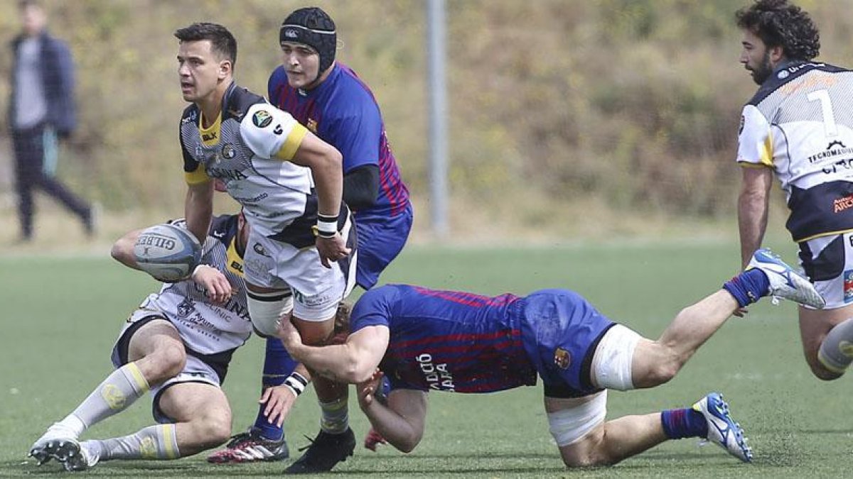 Todd Doolan es placado por un jugador del FC Barcelona en el inicio del choque disputado ayer en la Teixonera.-AREA 11