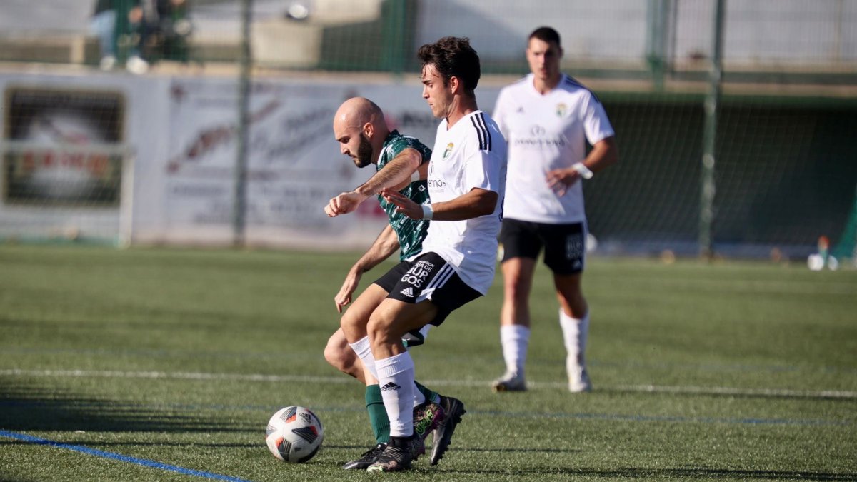 El blanquinegro, Lucas Ricoy, trata de mantener el esférico ante la presión de Óscar. Burgos CF
