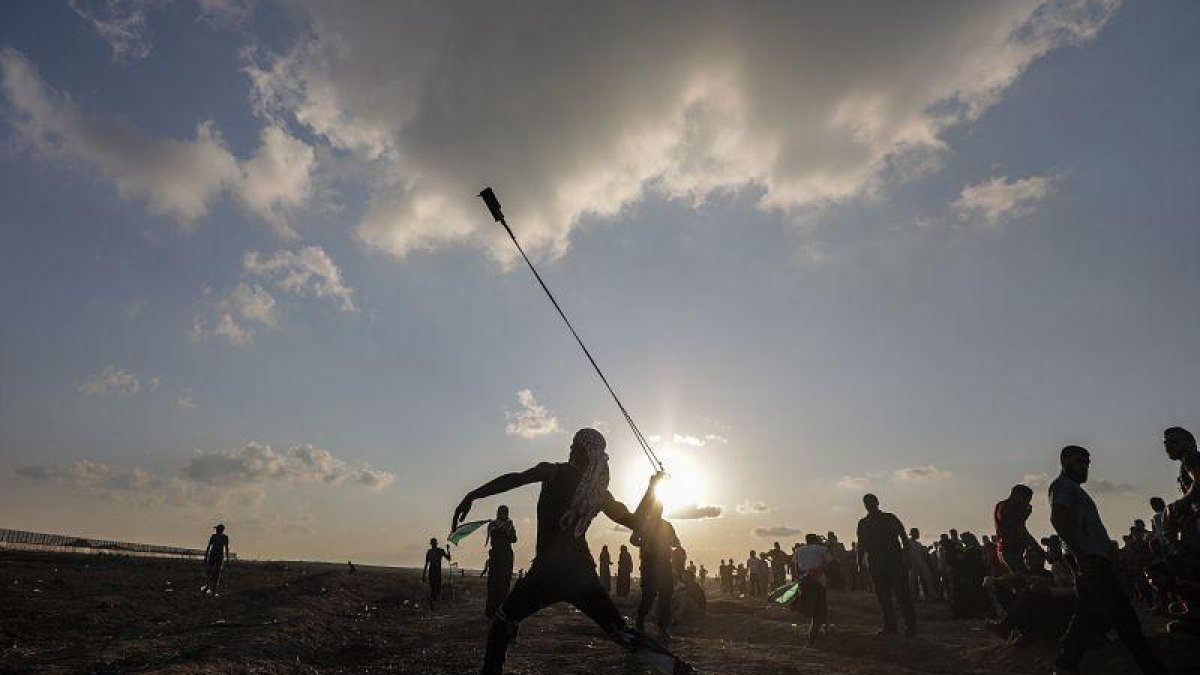 Un manifestante lanza una piedra con su honda durante unos disturbios en la frontera con Israel tras los rezos del Viernes, en Gaza, Cisjordania.-EFE