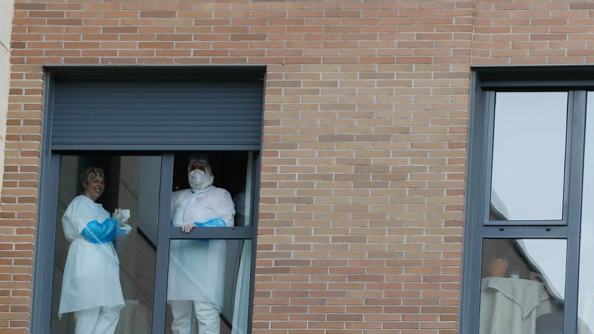 Personal de una residencia asomado a una ventana.  JUAN MIGUEL LOSTAU.
