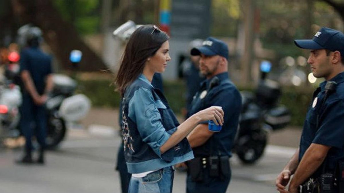 Kendall Jenner en el nuevo anuncio de Pepsi se detiene ante un policía y le ofrece el refresco en plena manifestación.-TWITTER