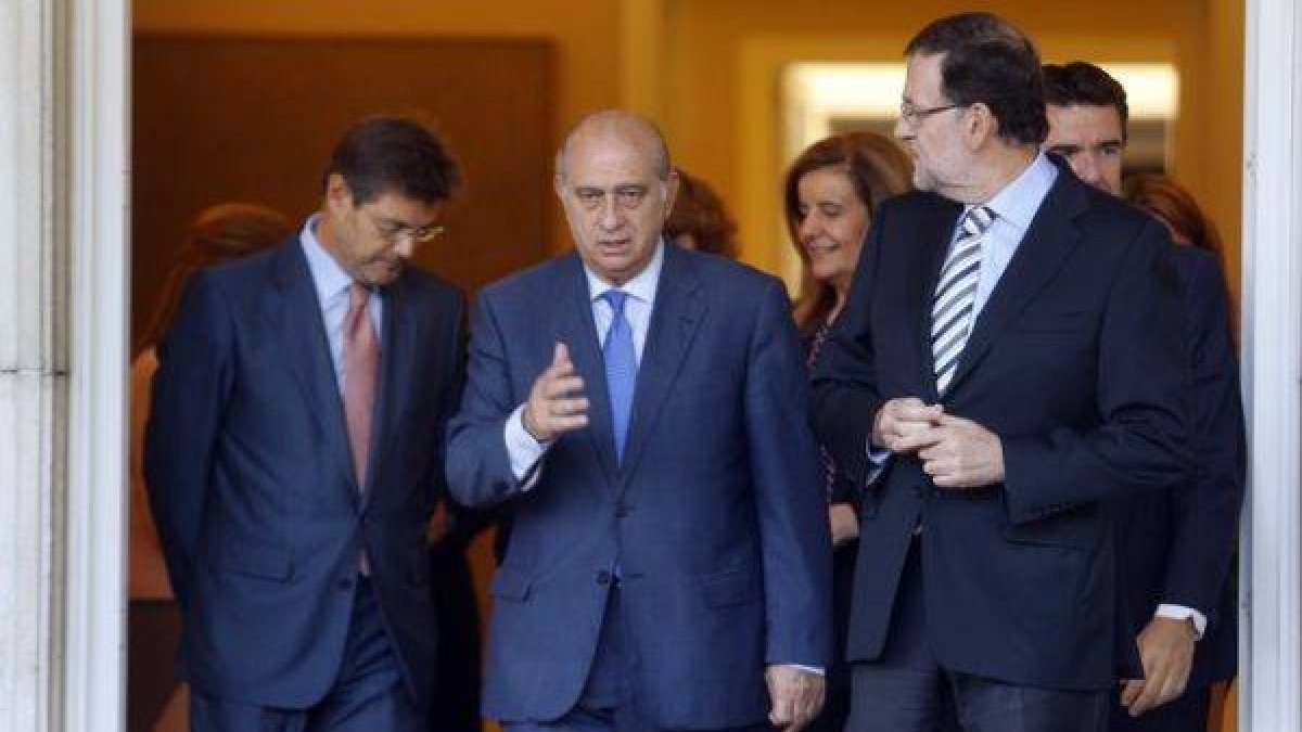 El ministro Jorge Fernández Díaz habla con Mariano Rajoy, a las puertas de la Moncloa, el pasado 3 de octubre.-