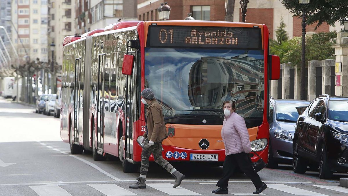 Dos personascon mascarilla cruzan por delante de un autobús en la calle Vitoria. RAÚL G. OCHOA