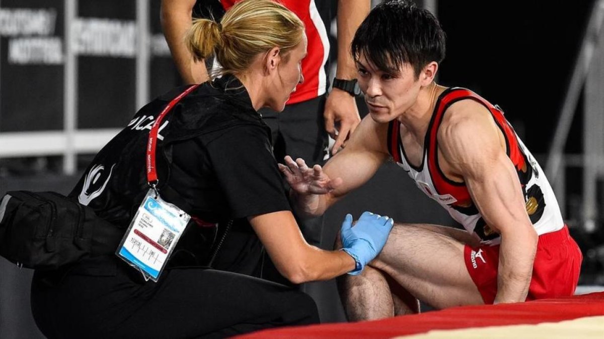 Kohei Uchimura es atendido tras torcerse el tobillo en la prueba de salto-AFP / MINAS PANAGIOTAKIS
