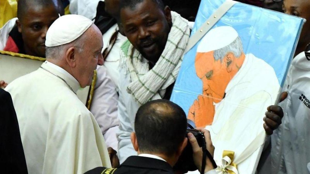 Un inmigrante muestra al Papa el retrato que le ha hecho, durante la audiencia general de los miércoles en el Vaticano.-EFE/ ETTORE FERRARI