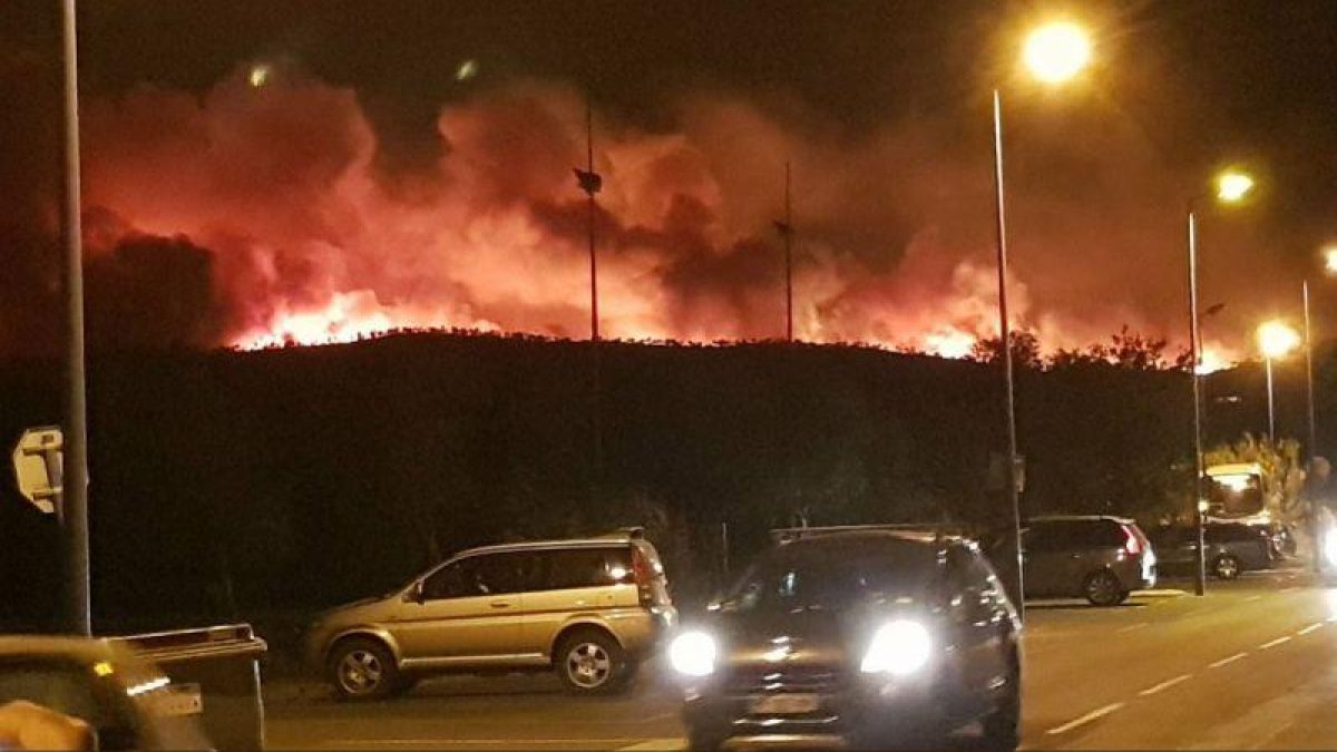 Una columna de llamas, al fondo, esta noche, en el gran incendio de Bormes-les-Mimosas.-EL PERIÓDICO (@JOHANROUQUET / @INFOEMERG)