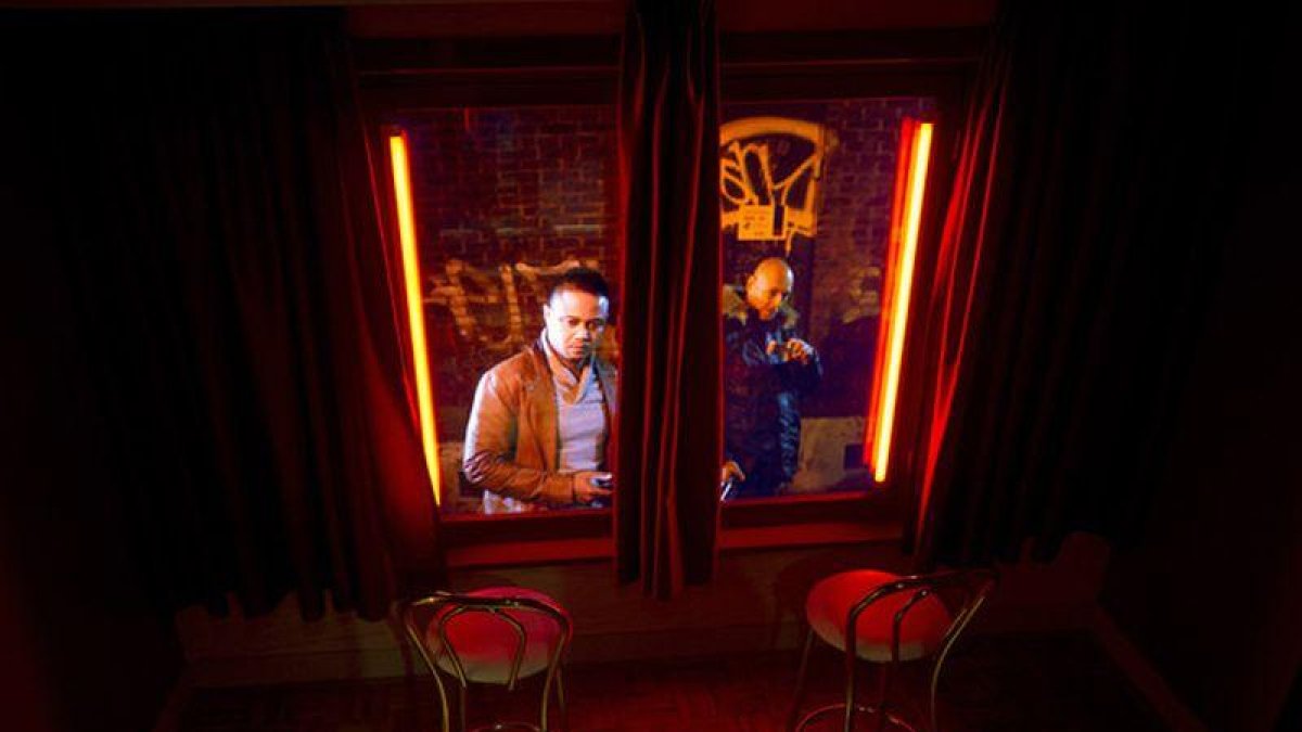 Unos visitantes miran desde fuera un escaparate rojo en el museo de la prostitución del Barrio Rojo de Amsterdam.-EVERT ELZINGA (AP)