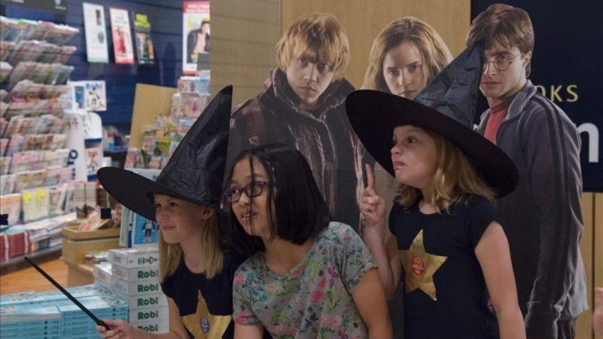 Fans de Harry Potter, la noche del sábado al domingo en Singapur, celebrando el lanzamiento mundial del nuevo libro de la saga del niño mago.-AFP / ROSLAN RAHMAN
