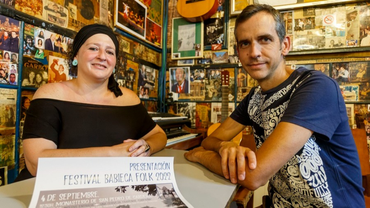 Pili Canal y Rodrigo Jiménez, organizadores del Babieca Folk, con el cartel de la fiesta de presentación en el Patillas. SANTI OTERO