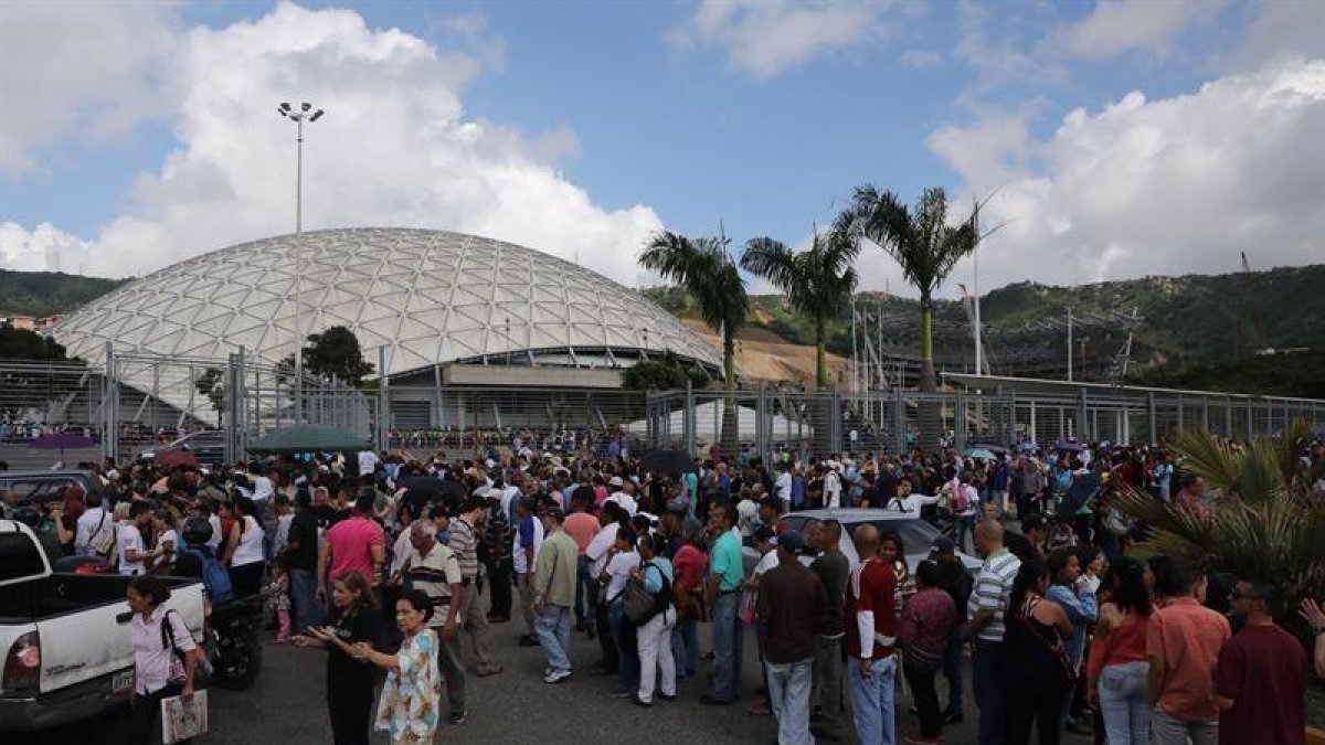 Ciudadanos hacen fila para ingresar al centro de votación de contingencia