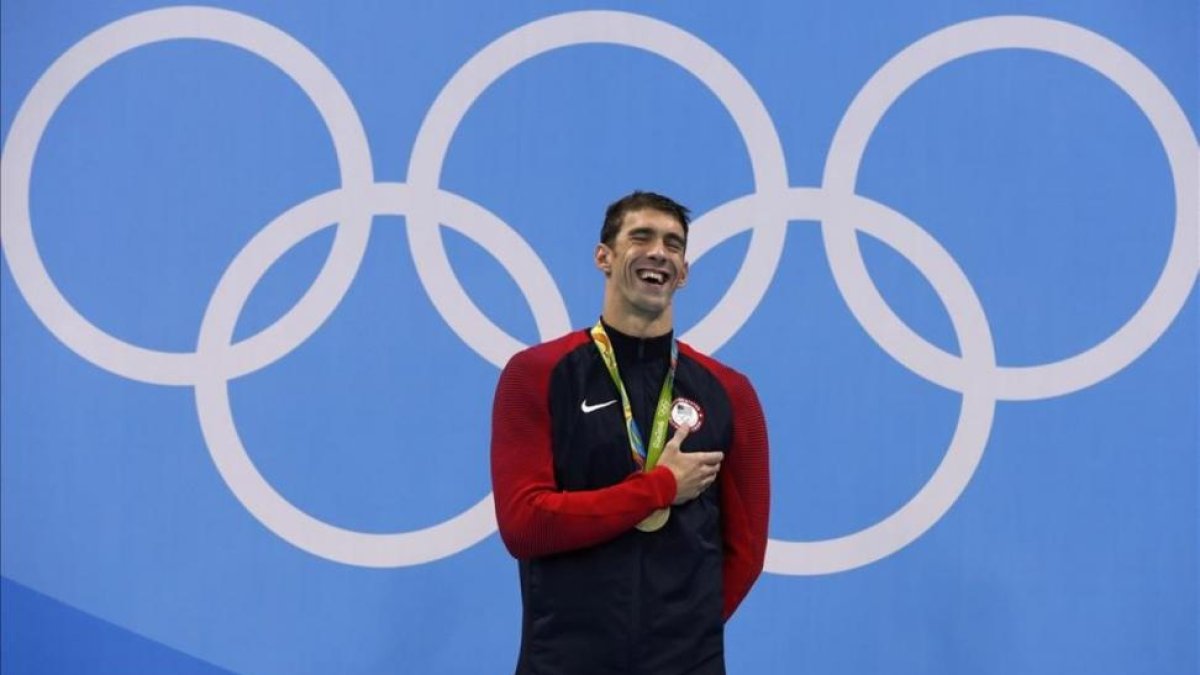 Phelps sonríe en el podio con el oro con el que recupera el título olímpico en los 200 mariposa.-ODD ANDERSEN / AFP