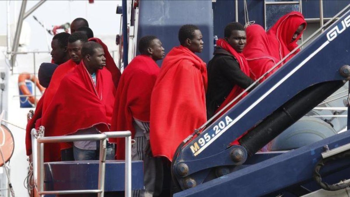 Varios inmigrantes a su llegada al puerto de Almeria tras ser rescatados por Salvamento Maritimo.-EFE / CARLOS BARBA