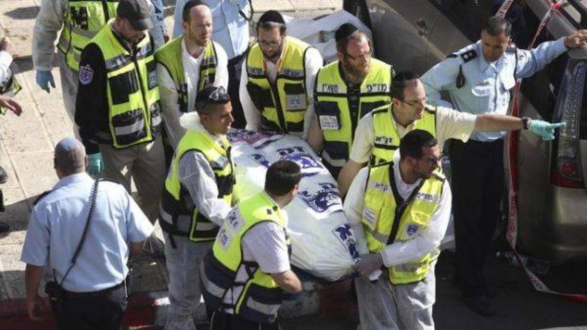 Personal sanitario retira el cadáver de una de las víctimas del atentado, este martes en Jerusalén.-Foto: EFE / ABIR SULTAN