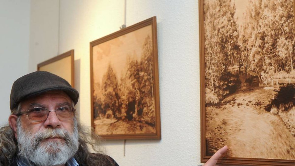 El artista Arsenio Peña junto a sus obras en la sala del Consulado del Mar.-Israel L. Murillo