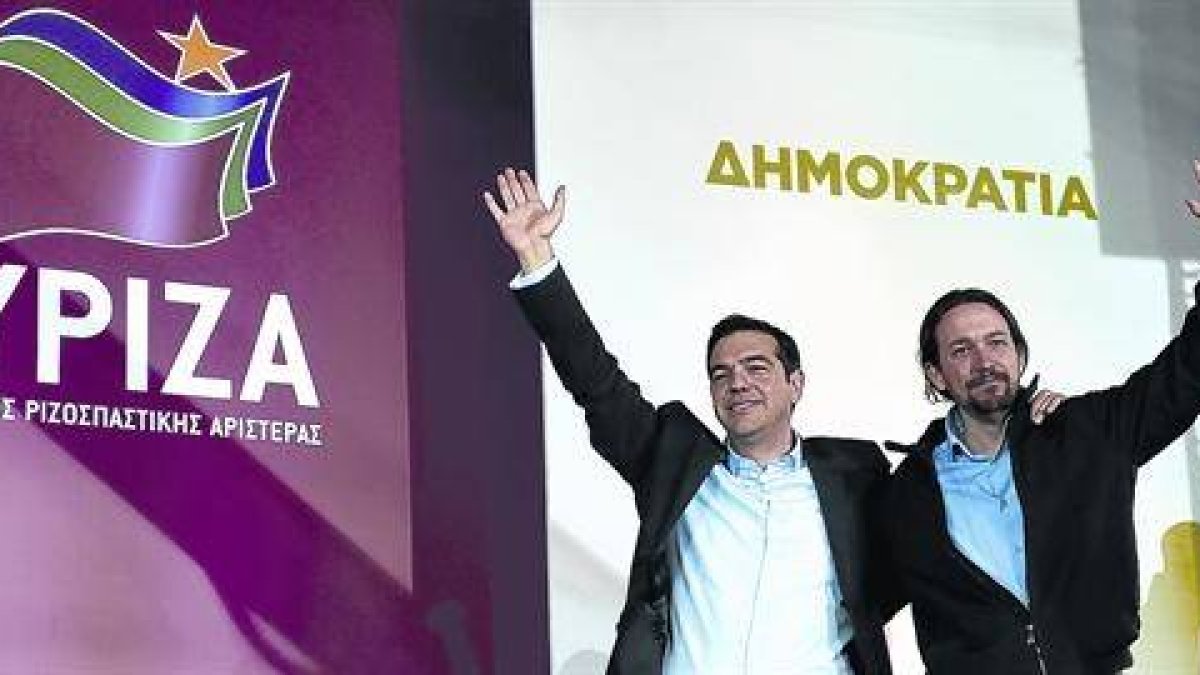Tsipras, líder de Syriza, se abraza a Pablo Iglesias, su homólogo en Podemos, tras el mitin de ayer en la plaza Omonia de Atenas.-Foto: AP / LEFTERIS PITARAKIS
