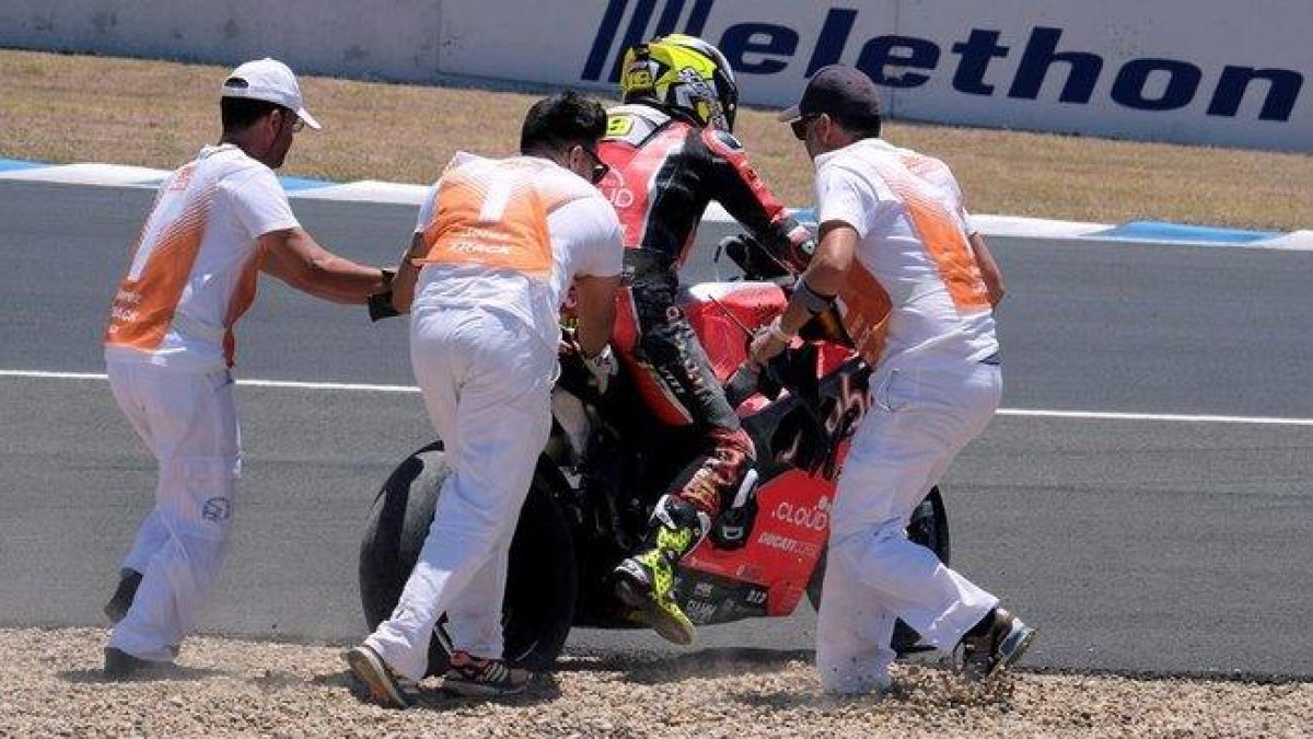 Los comisarios de la primera curva de Jerez tratan de que Álvaro Bautista (Ducati) pueda regresar a la carrera tras su caída en la segunda vuelta.-EFE / ROMÁN RIOS