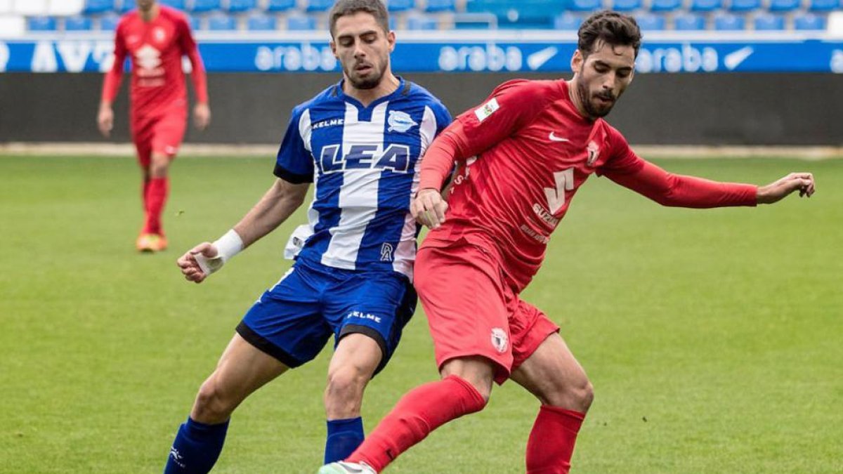 Julio Rico protege el balón ante la presión de un jugador alavesista.-@Alaves