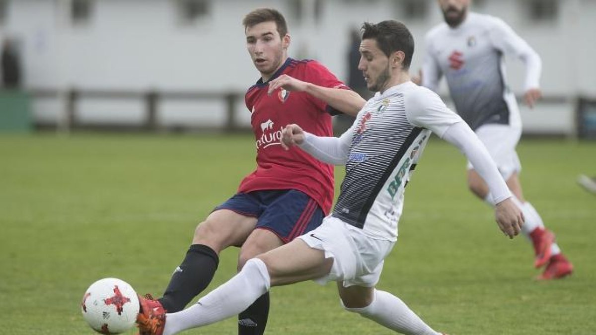 Adrián Cruz, que ayer regresó al once inicial, pelea por un balón con un jugador de Osasuna B en Tajonar.-CA Osasuna