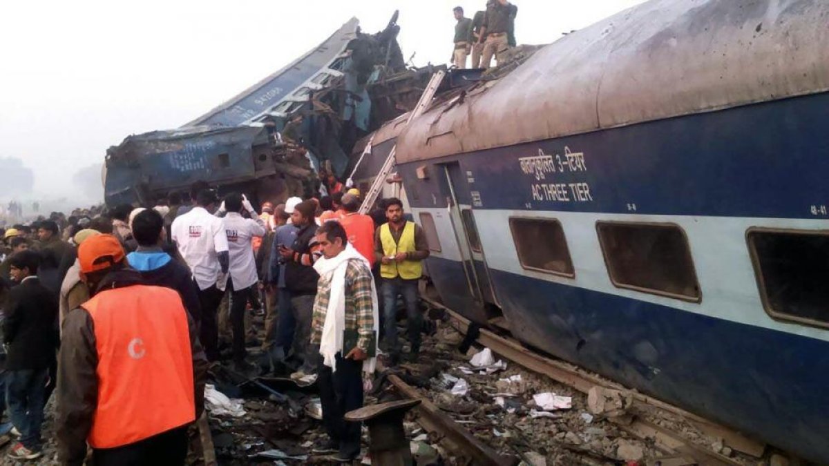 Equipos de rescate trabajan para recuperar supervivientes en el tren siniestrado cerca de Pukhrayan, en el distrito indio de Kanpur, hoy.-AFP