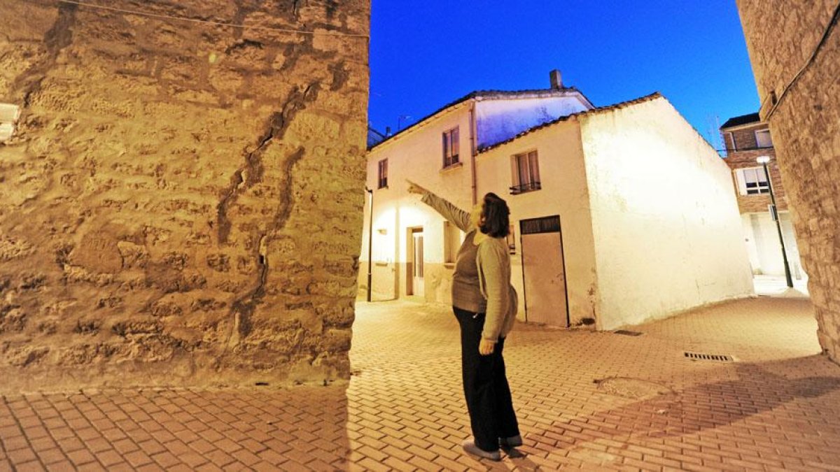 Una vecina señala varias grietas que se localizan en una vivienda del barrio burgalés.-ISRAEL L. MURILLO