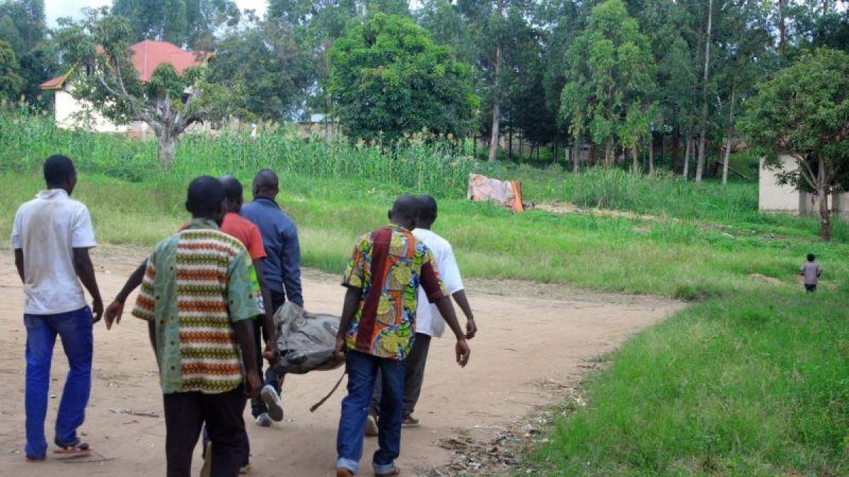 Residentes en una aldea del Congo trasladan el cadáver de una víctima de los choques del Ejército con el ADF.-FISTON MAHAMBA / AFP