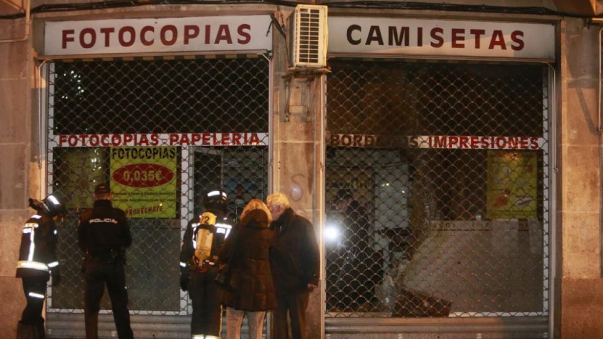 Bomberos y agentes de Policía junto a los dueños del local antes de inspeccionar con ellos el interior.-RAÚL G. OCHOA