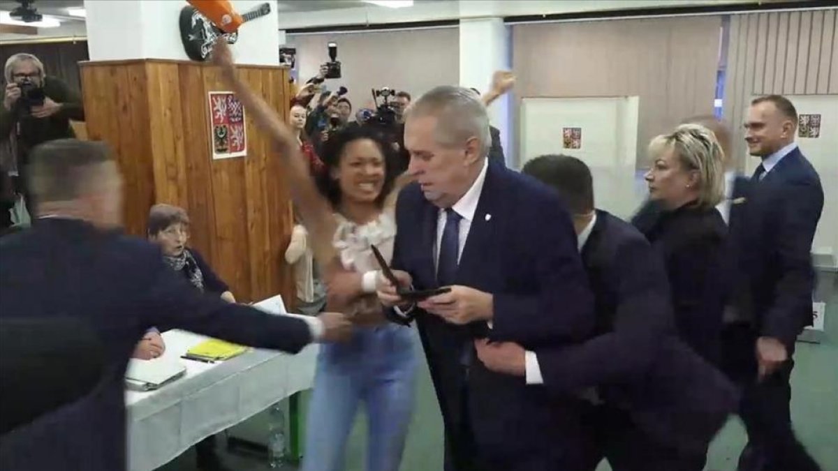 Momento en el que la activista de Femen se encara con el presidente de chequia, Milos Zeman.-/ AP / HYENA BERAN